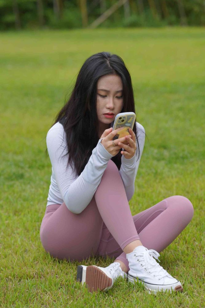 图片[1]-坐在草地玩手机的瑜伽姑娘【733P】04012-华仔美图